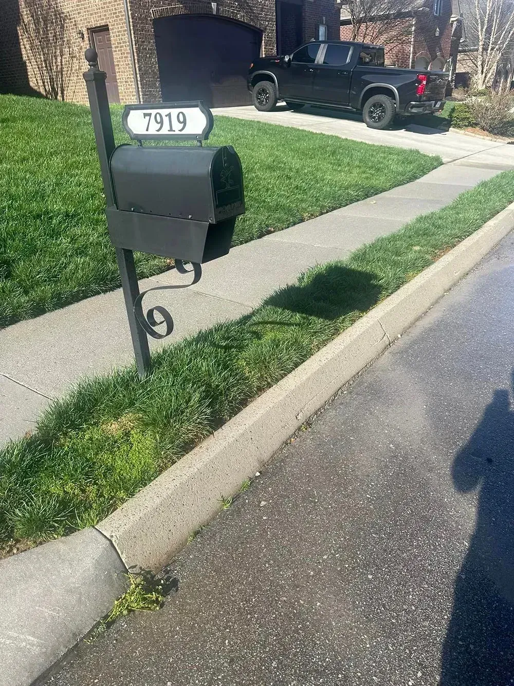 A dark-colored mailbox with the number 