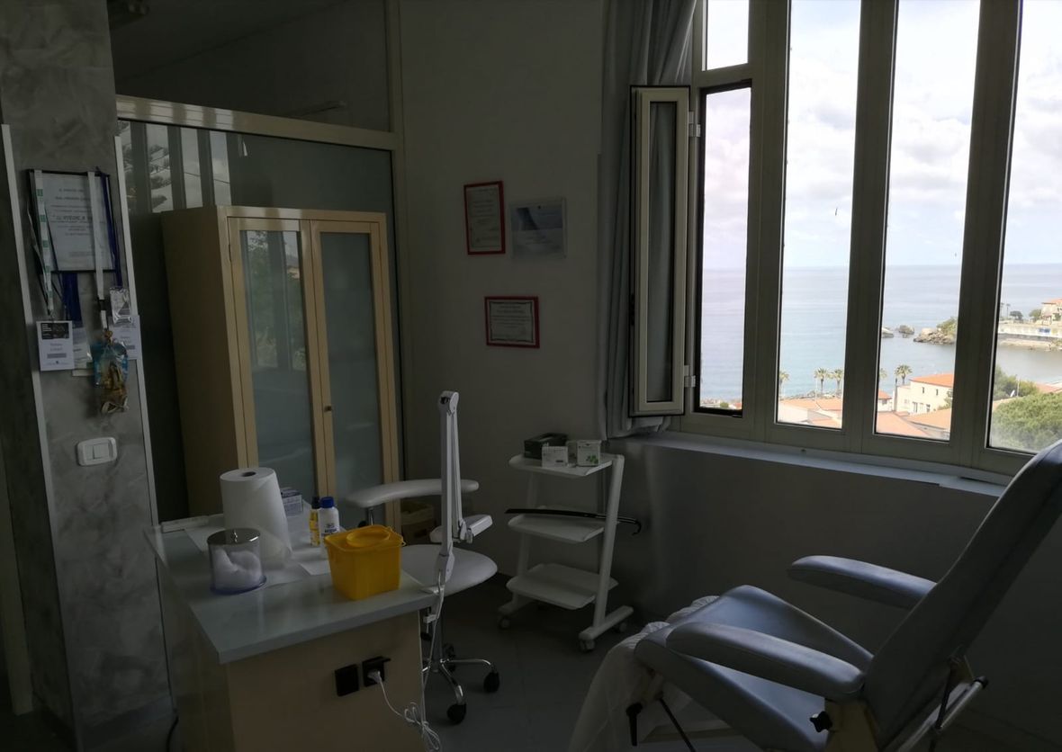 Una stanza con una sedia e una finestra con vista sull'oceano.