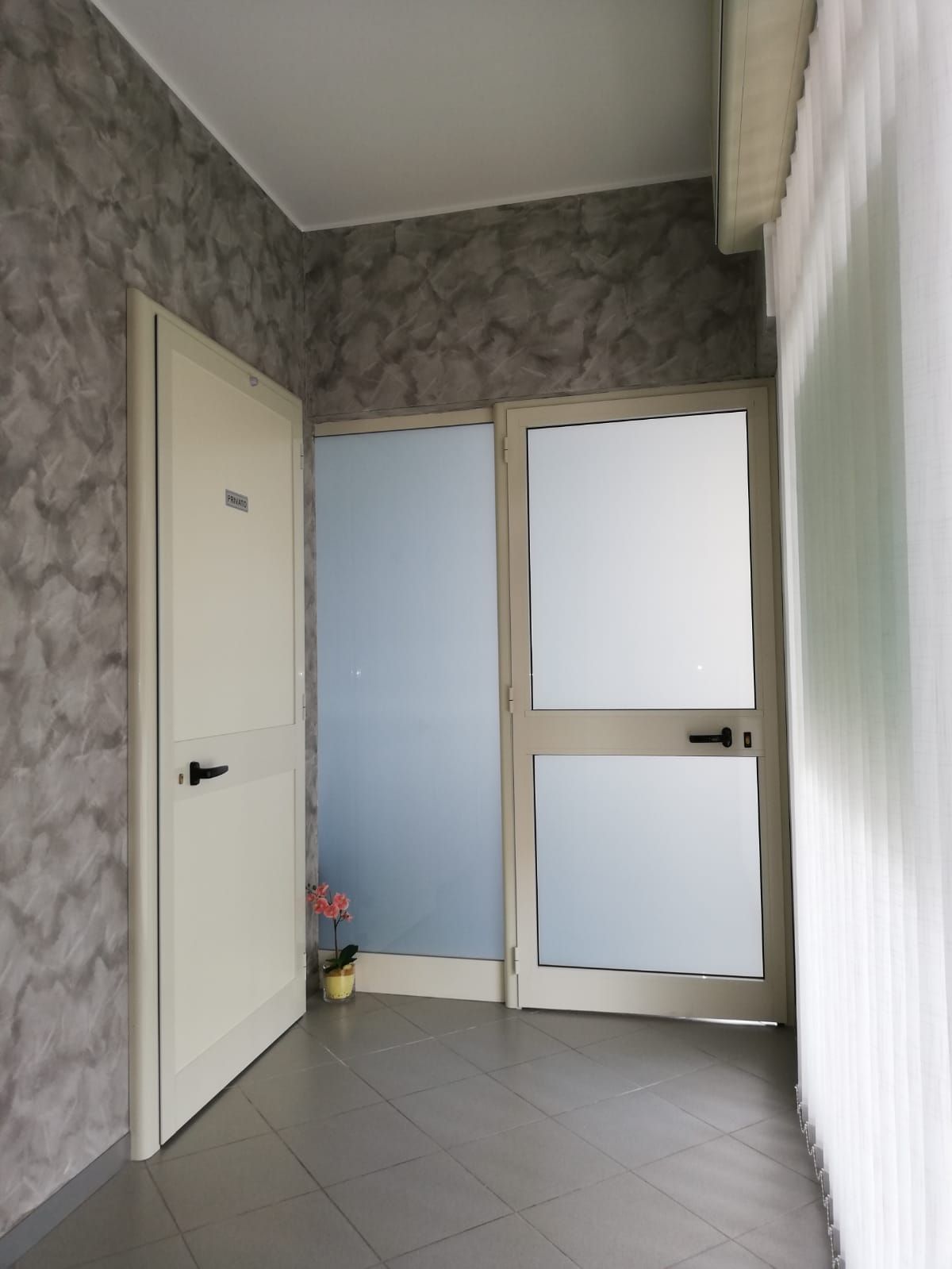 Un corridoio con una porta bianca e una porta blu