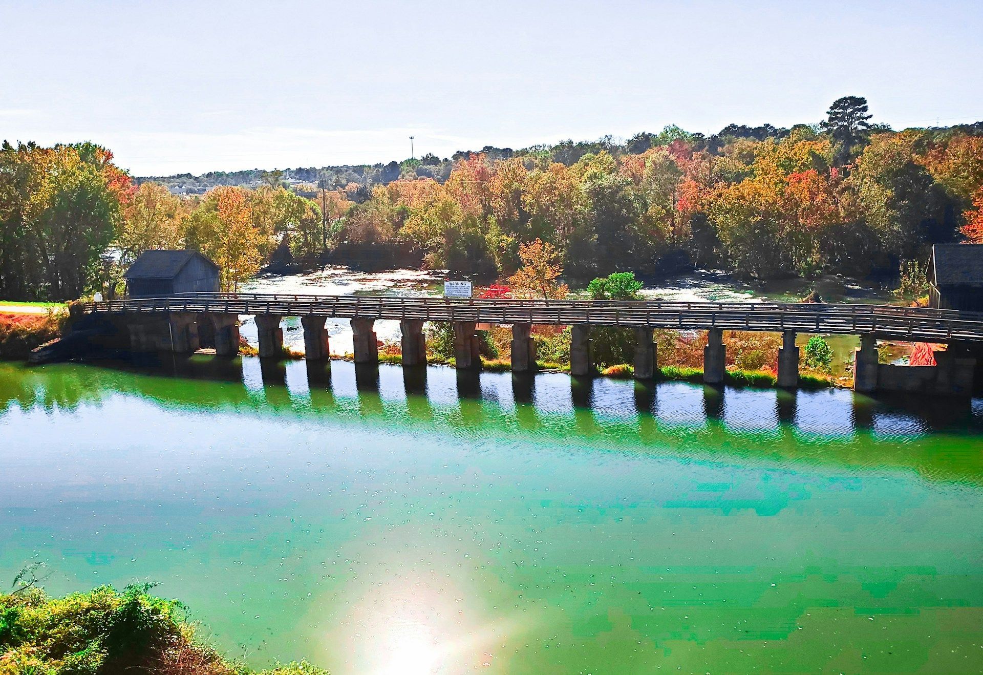A bridge over a body of water with trees in the background