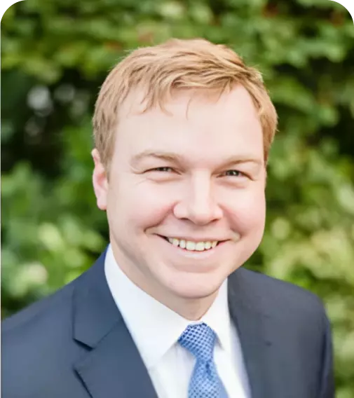 A man in a suit and tie is smiling for the camera.