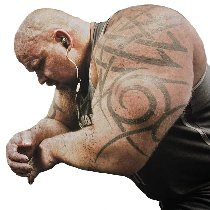 A man with a tattoo on his arm is wearing ear buds