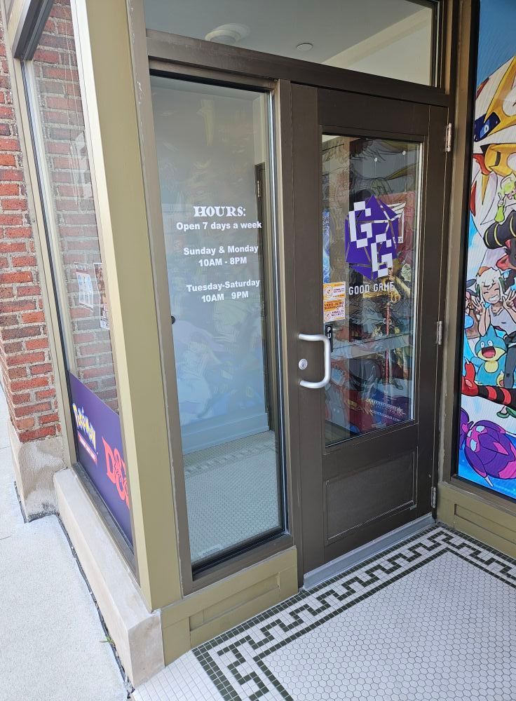 Storefront with glass door, hours posted. Brick building.