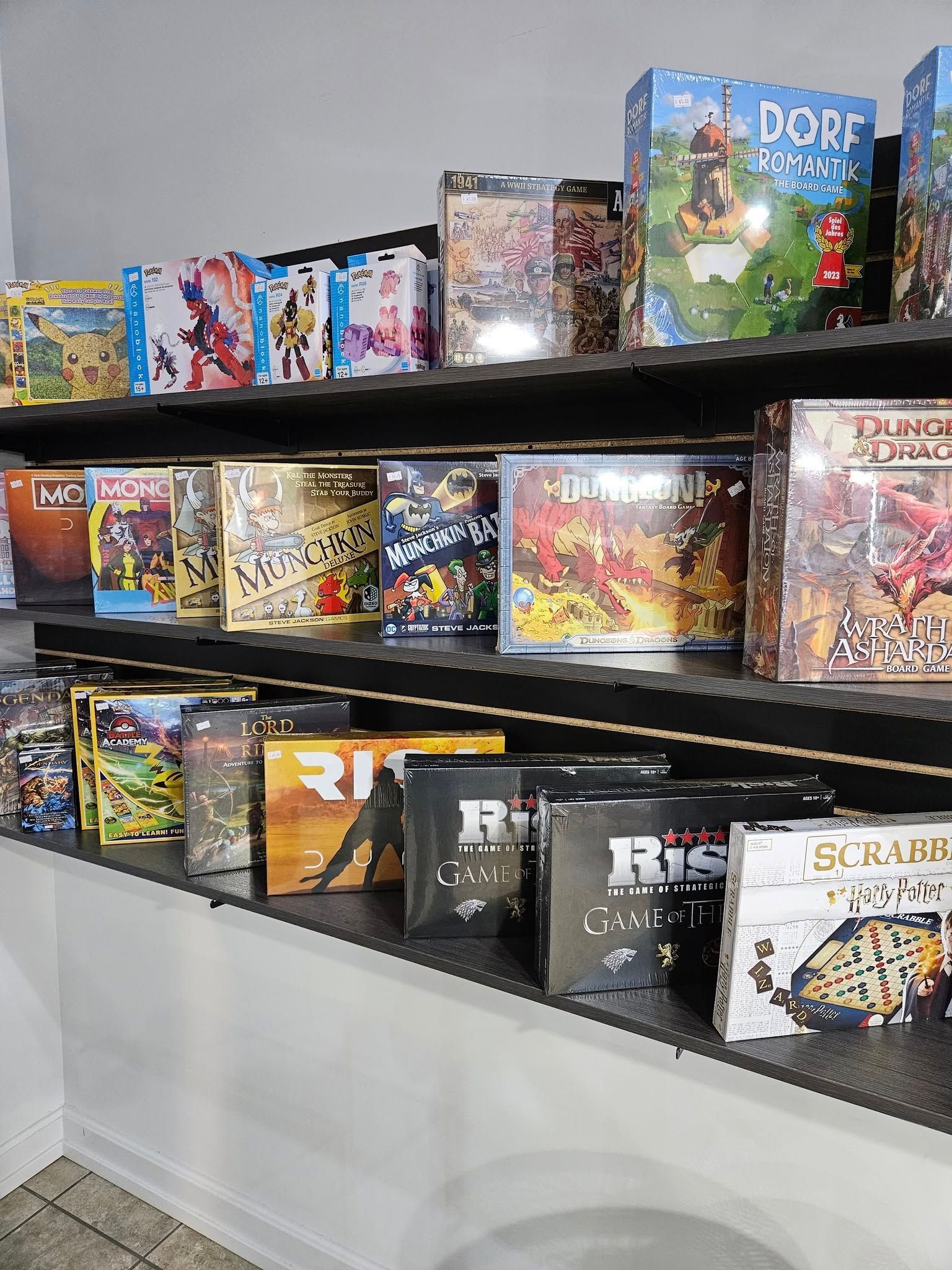 Shelf of board games for sale in a store, featuring various titles with colorful boxes.