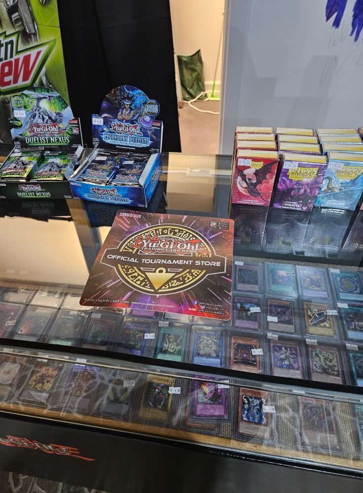 Yu-Gi-Oh! cards and packs displayed behind glass counter, including a box set.