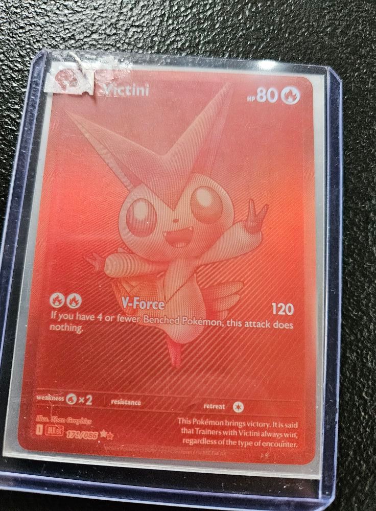 Victini Pokémon card, red and gold, in a protective sleeve.