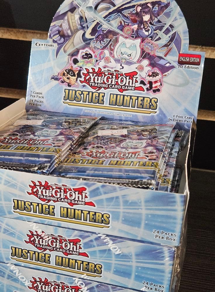 A box of Yu-Gi-Oh! Justice Hunters booster packs, blue and red design, stacked on top of each other.