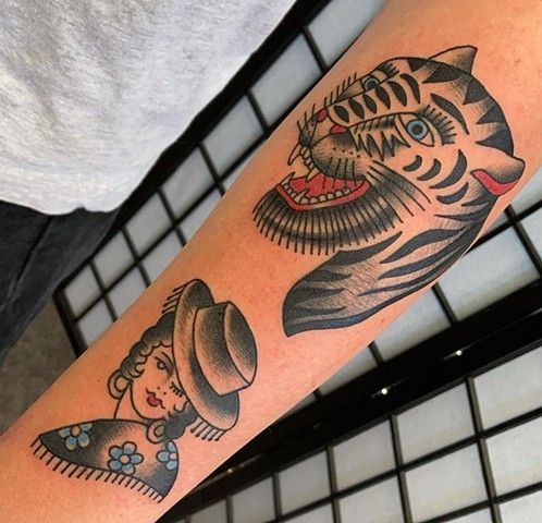 A tattoo of a woman and a tiger on a person 's arm
