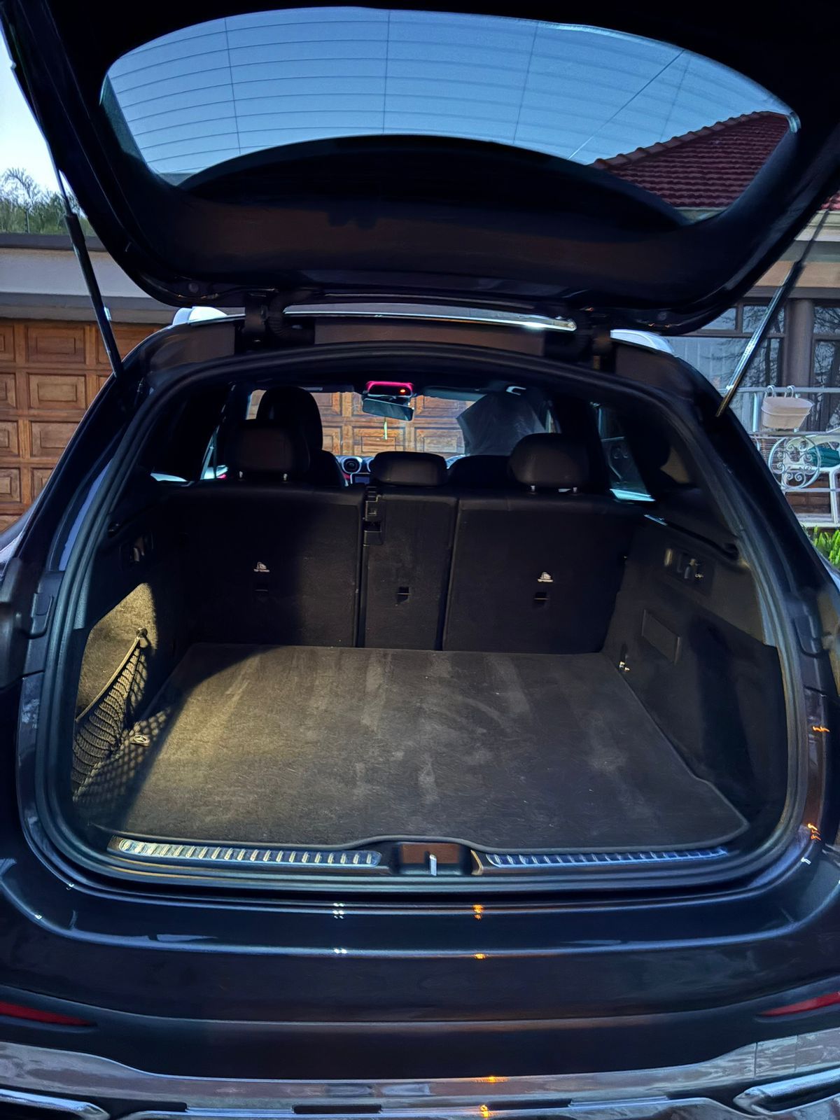 Open black SUV trunk with a dark carpeted interior.