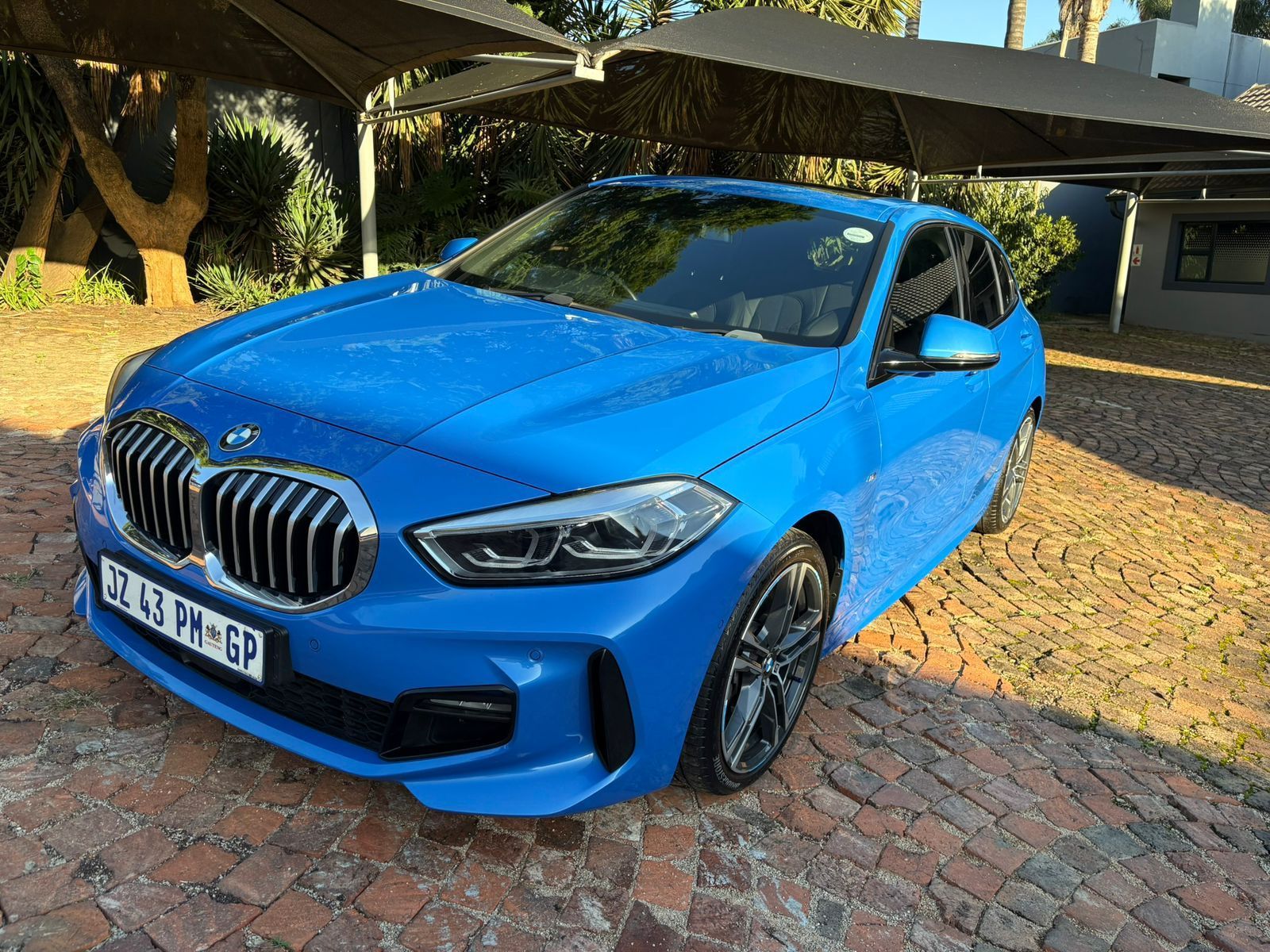 Blue BMW 1 Series parked outdoors.