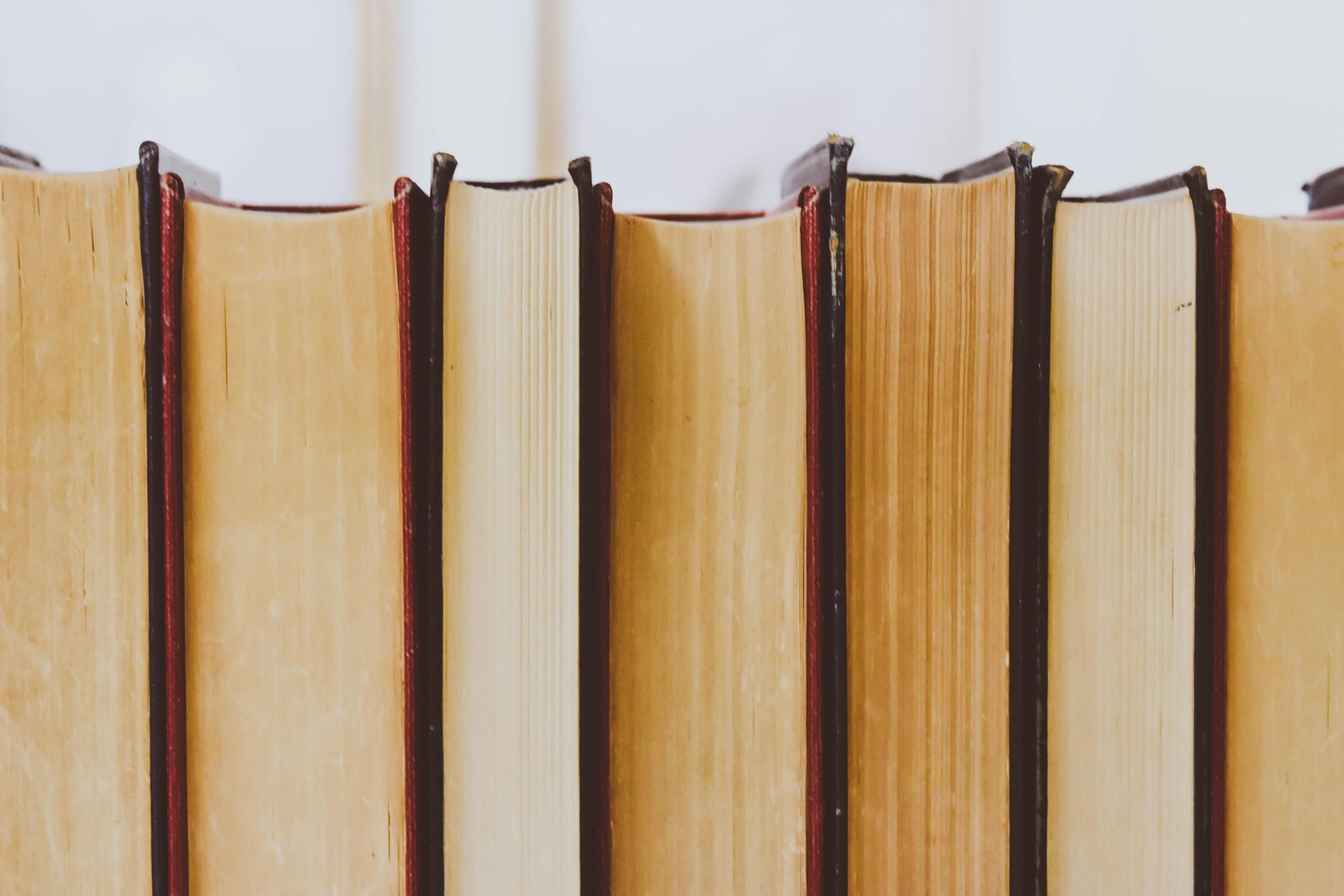 A row of books stacked on top of each other on a table.