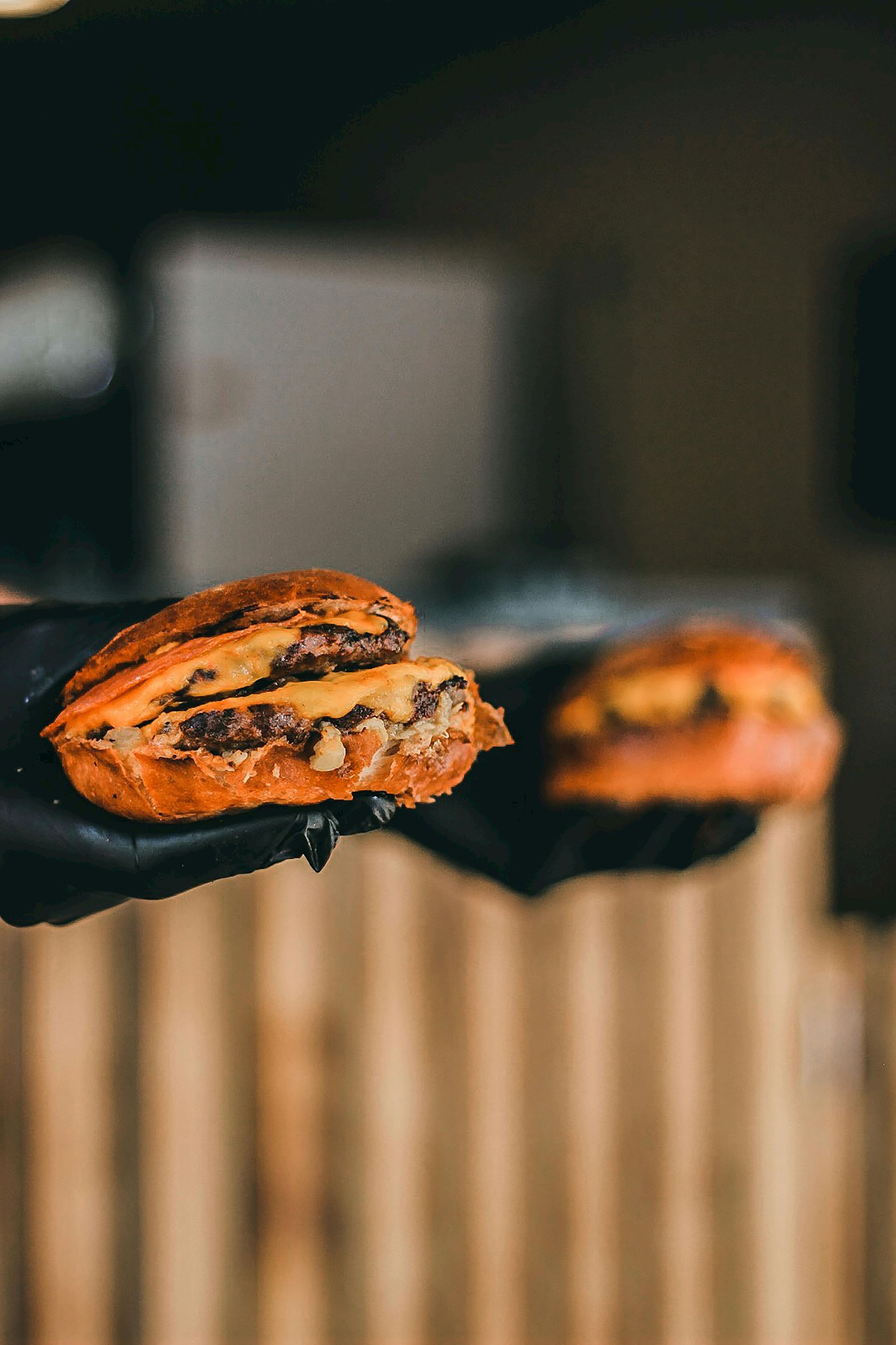Martini with two olives, garnished, on a wooden surface with a blurred outdoor background.