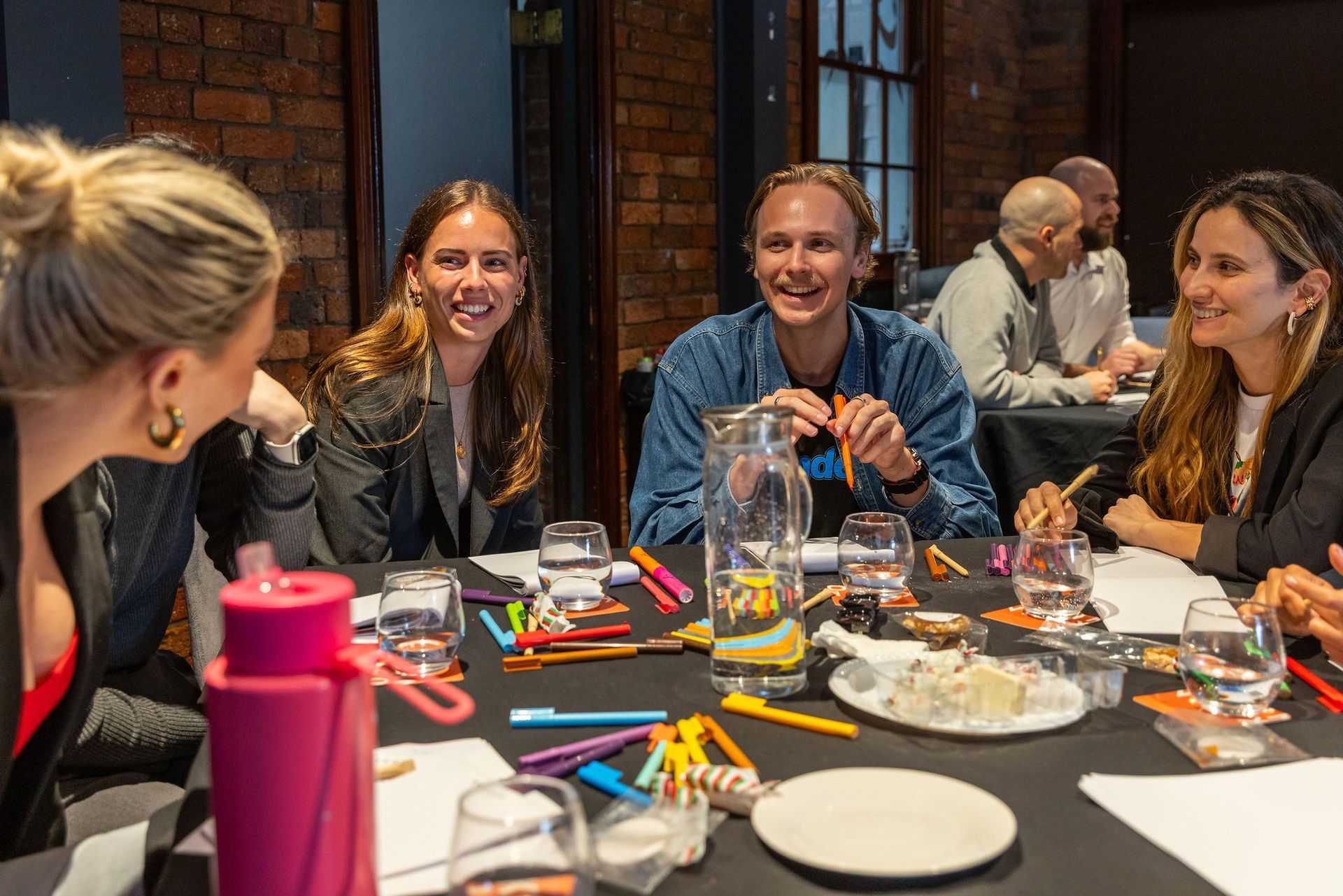 A group of people are sitting around a table laughing.