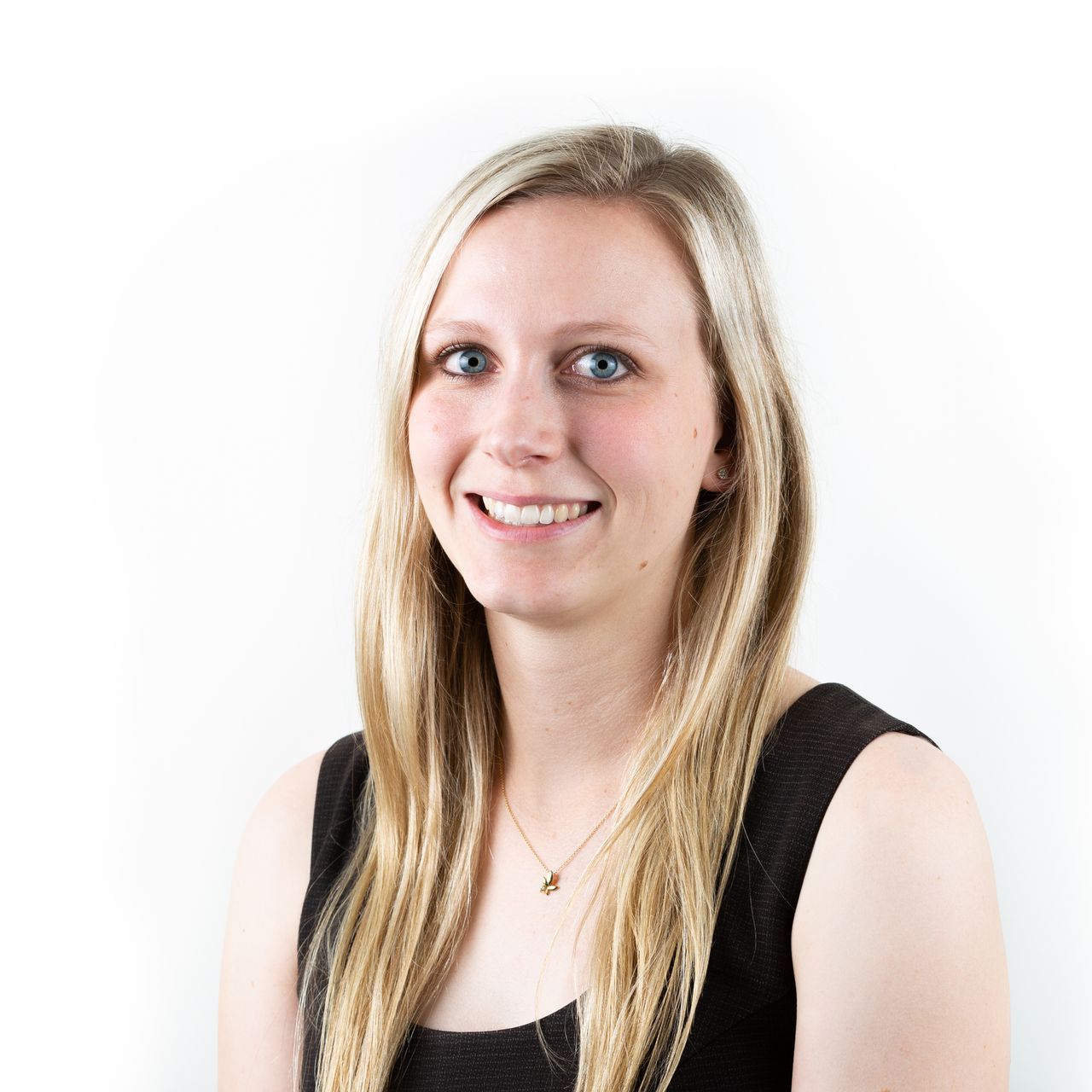 A woman with long blonde hair is smiling and wearing a black tank top