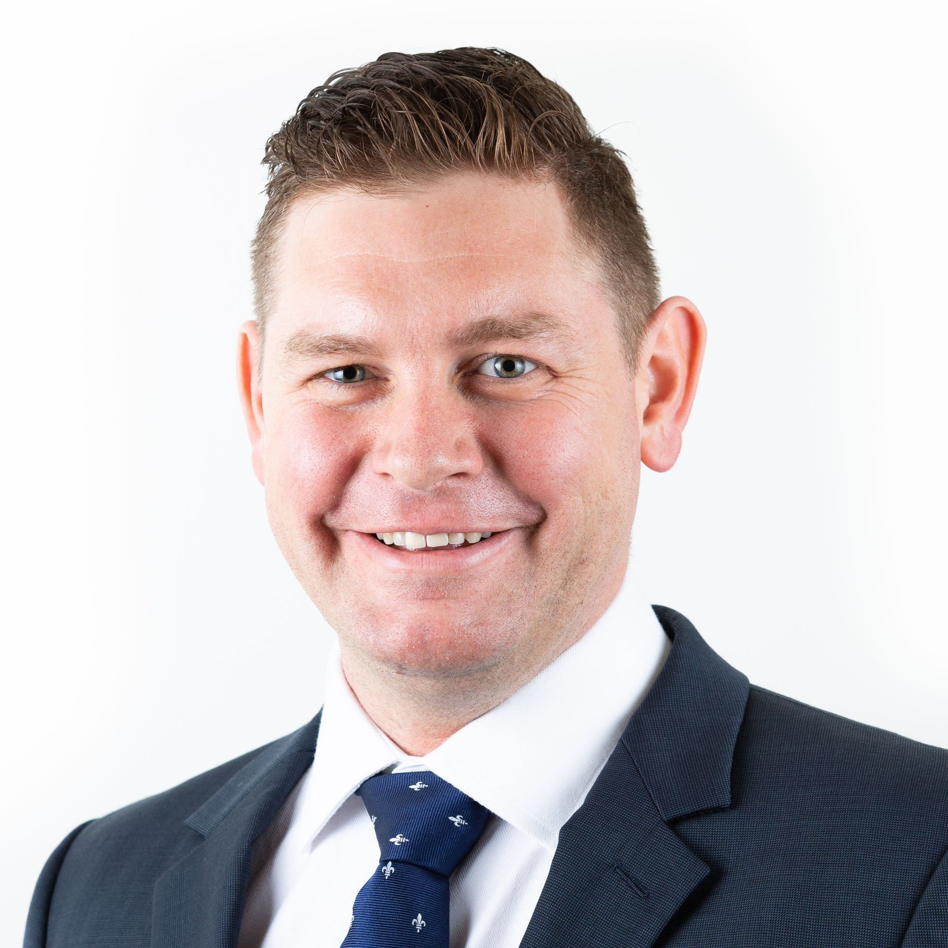 A man in a suit and tie is smiling for the camera.