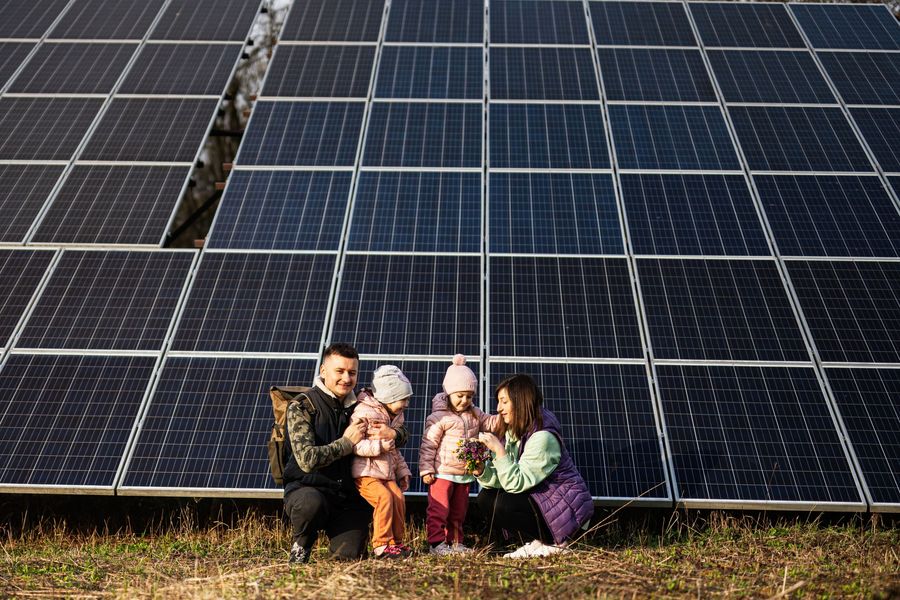 Solar panels installed on a Spanish tile roof against a hillside.