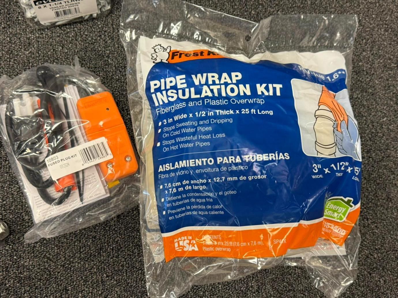 Two sealed plastic bags containing a pipe wrap insulation kit and a black cord.