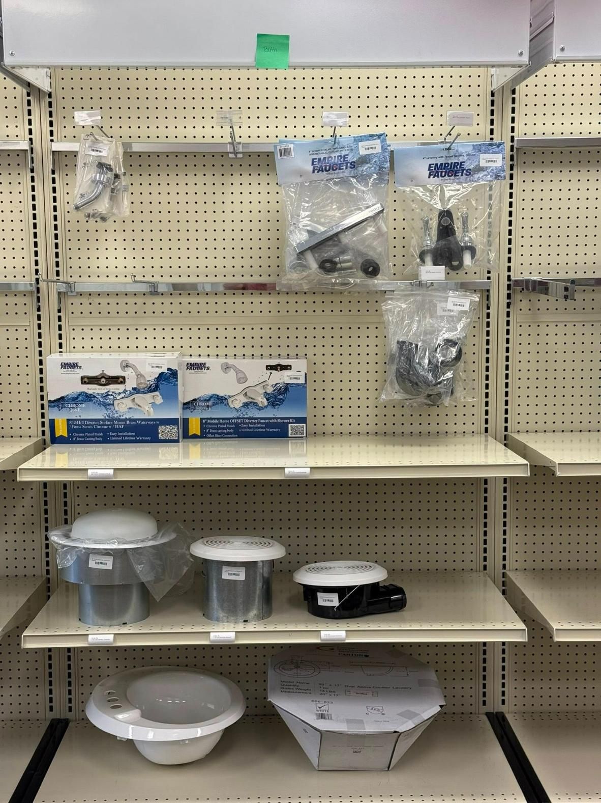Shelves displaying various plumbing parts, including faucets, valves, and drain components.