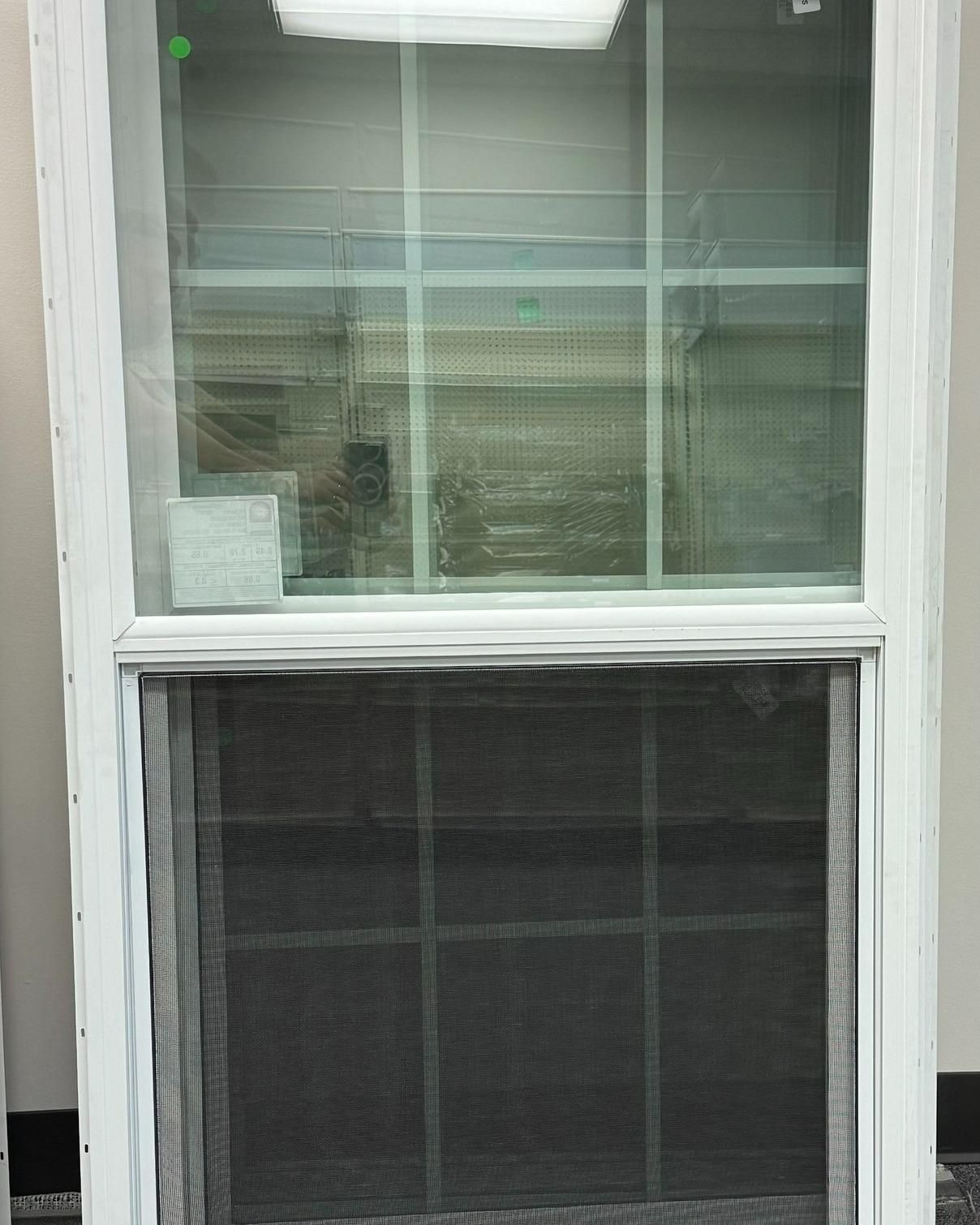 White window with a black screen at the bottom.  Reflections visible through the glass.