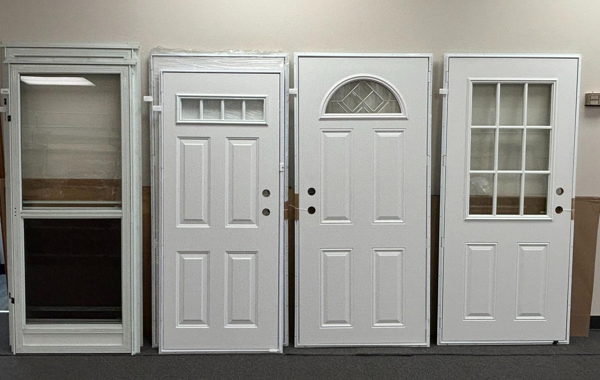 Four white exterior doors of different styles against a gray background.
