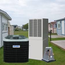 Air conditioning units outside a house in a yard, near other houses on a cloudy day.