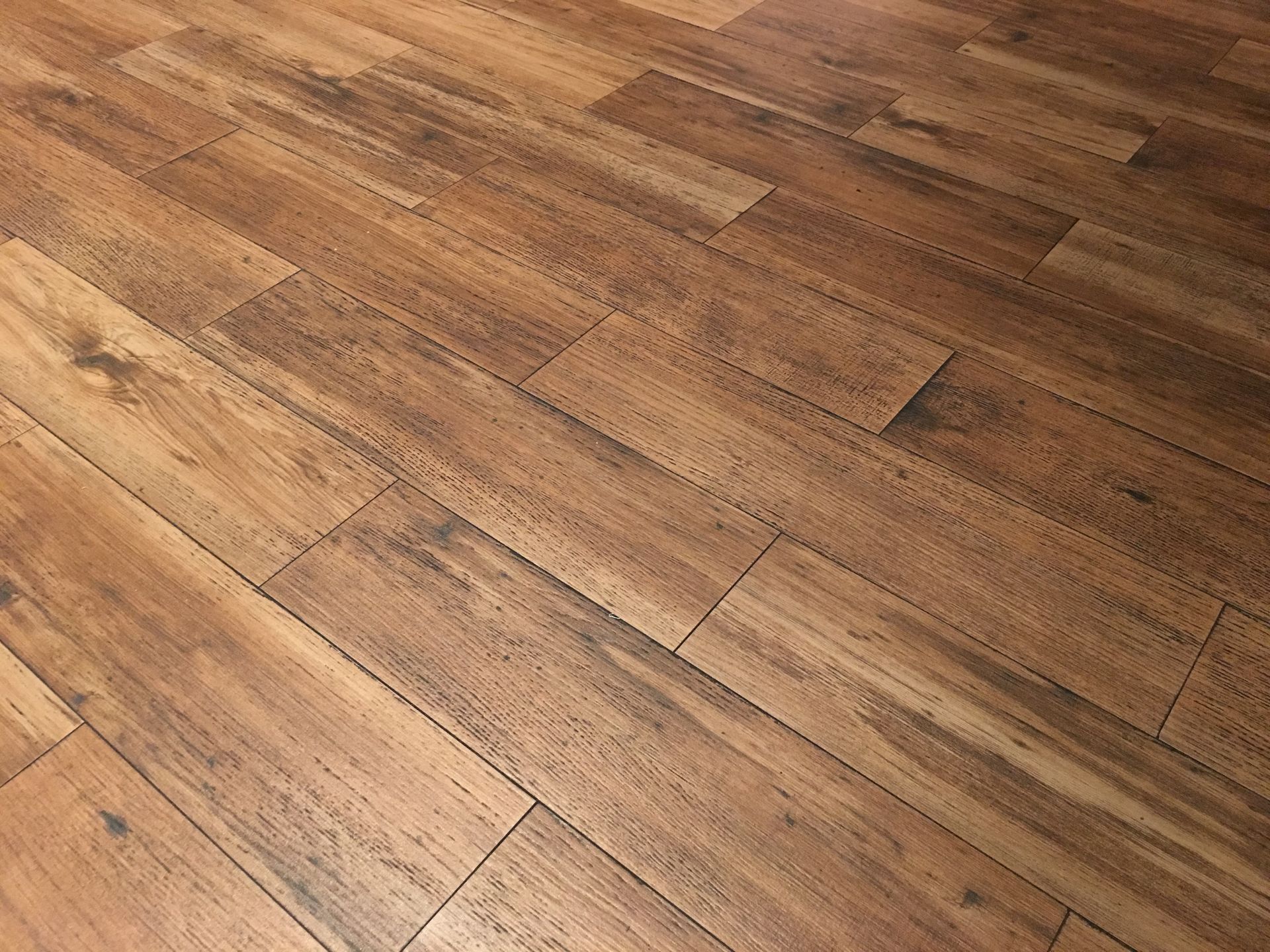 Wooden floorboards, arranged in a diagonal pattern, show variations in brown tones.