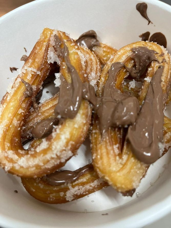Churros ricoperti di cioccolato in una ciotola bianca