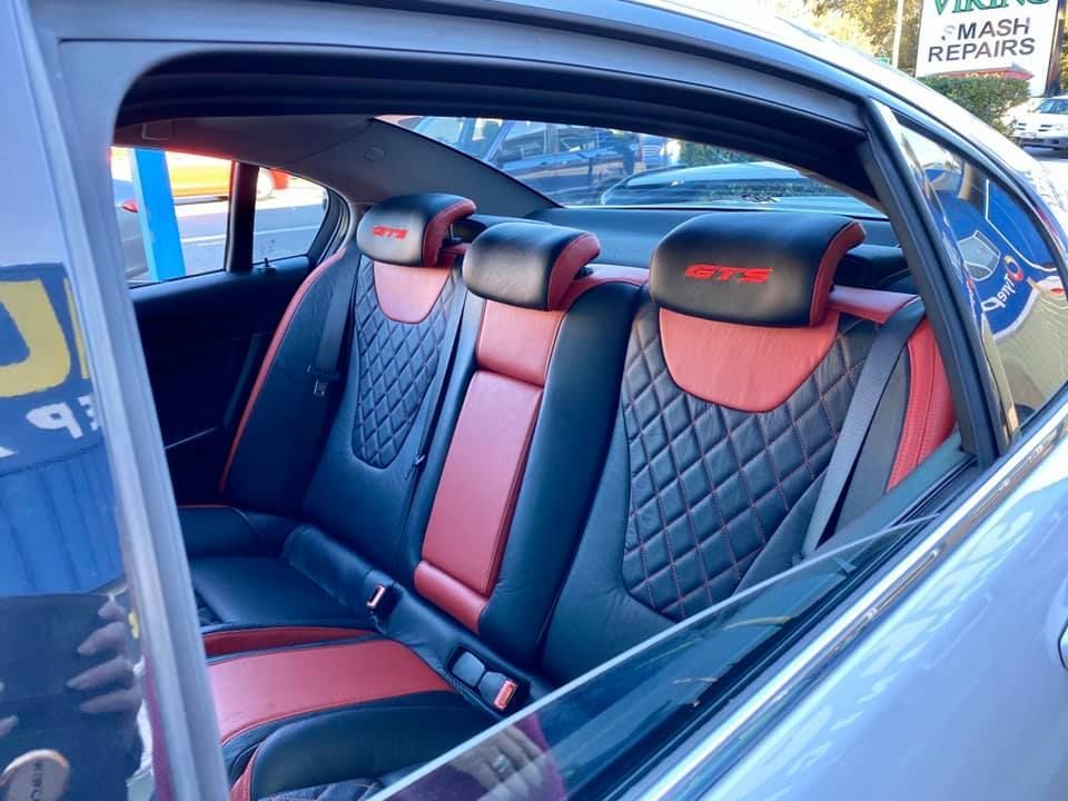 The Back Seat of a Car With a Red and Black Seat Cover — Currumbin Trimmers  In Currumbin Waters, QLD