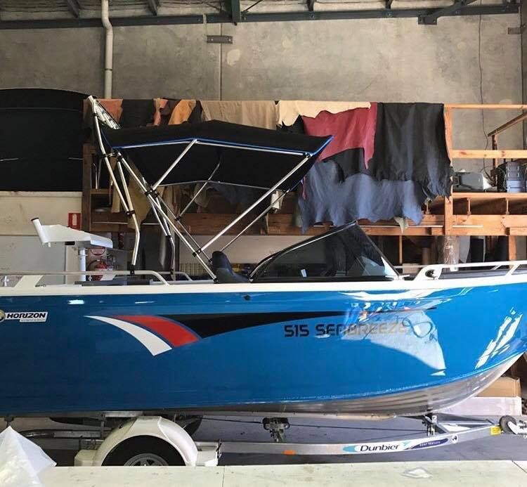 A Blue Boat With a Canopy is Parked in a Garage — Currumbin Trimmers In Murwillumbah, NSW
