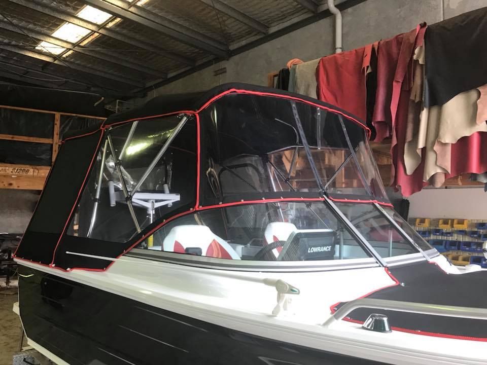 A Black and White Boat With a Red Trim is Sitting in a Warehouse — Currumbin Trimmers In Burleigh Heads, QLD