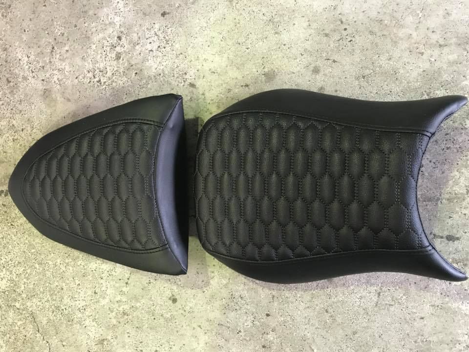 A Pair of Black Motorcycle Seats Are Sitting on Top of a Concrete Surface — Currumbin Trimmers In Tweed Heads, NSW