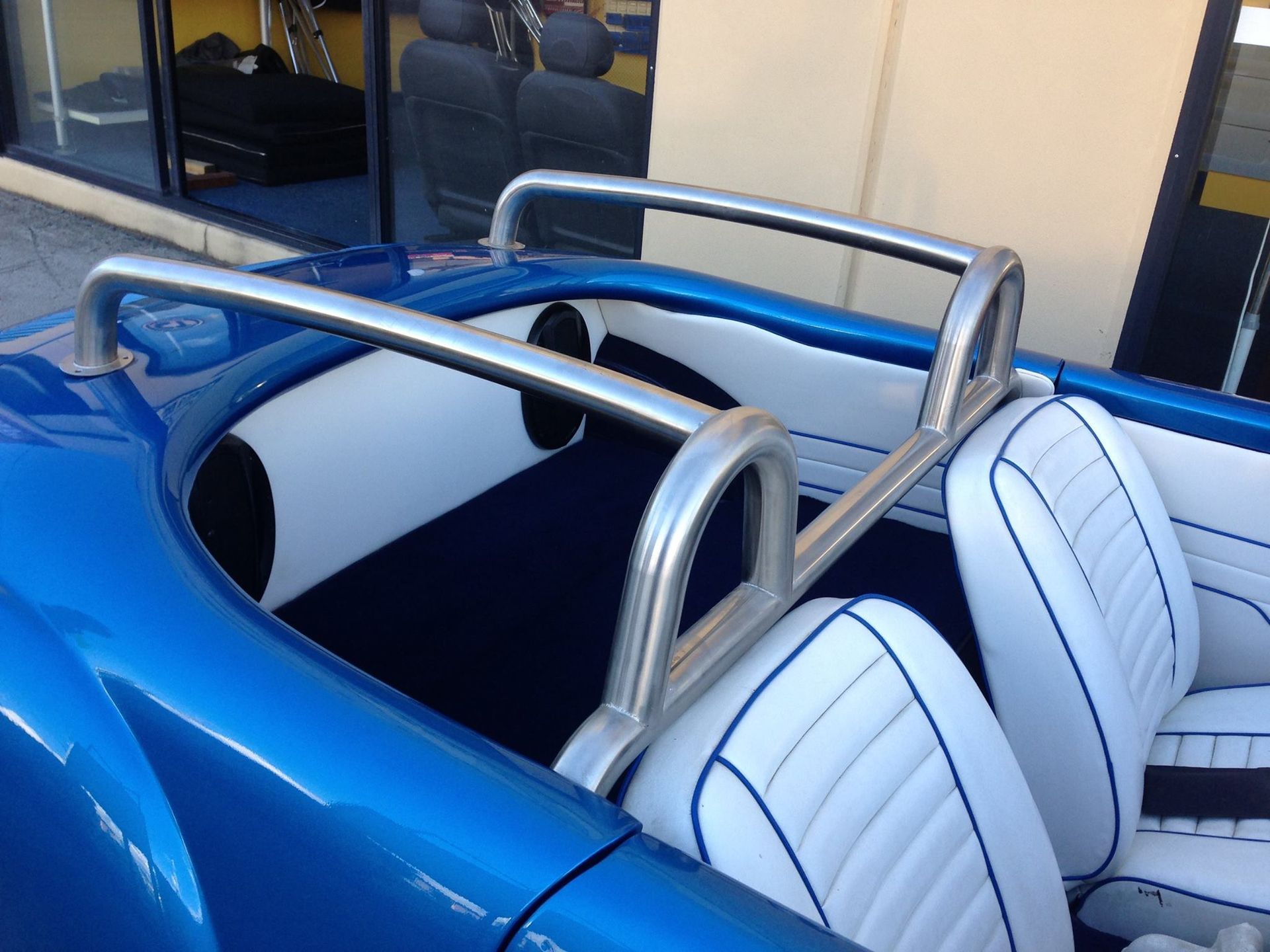 A Blue Car With White Seats is Parked in Front of a Building — Currumbin Trimmers In Burleigh Heads, QLD
