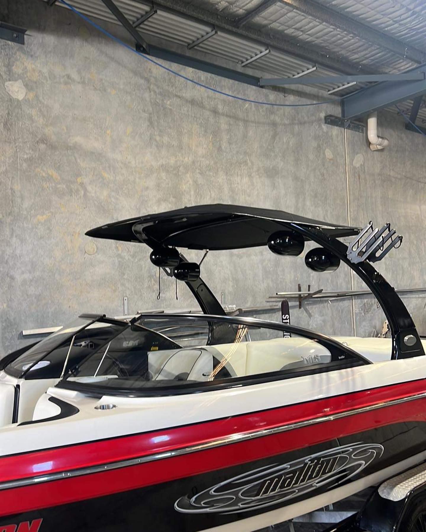 A Red and White Boat is Parked in a Garage — Currumbin Trimmers In Byron Bay, NSW