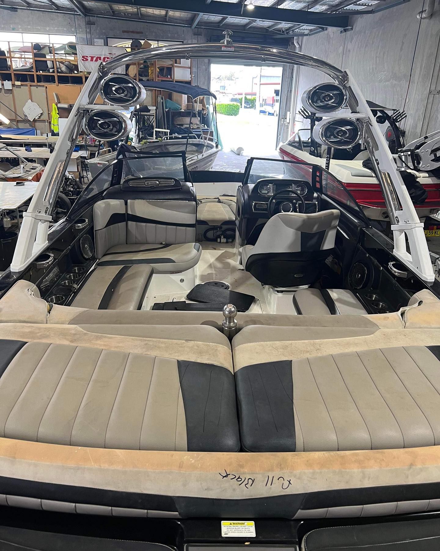 A Boat is Sitting in a Warehouse With Speakers on Top of It — Currumbin Trimmers In Byron Bay, NSW