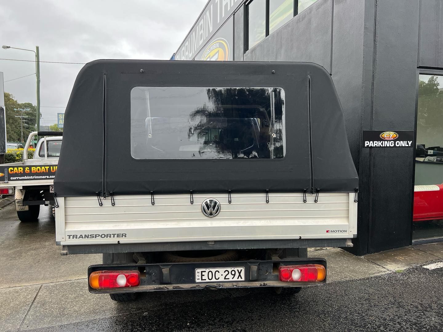 A White Truck With a Black Canopy is Parked in Front of a Building — Currumbin Trimmers In Byron Bay, NSW