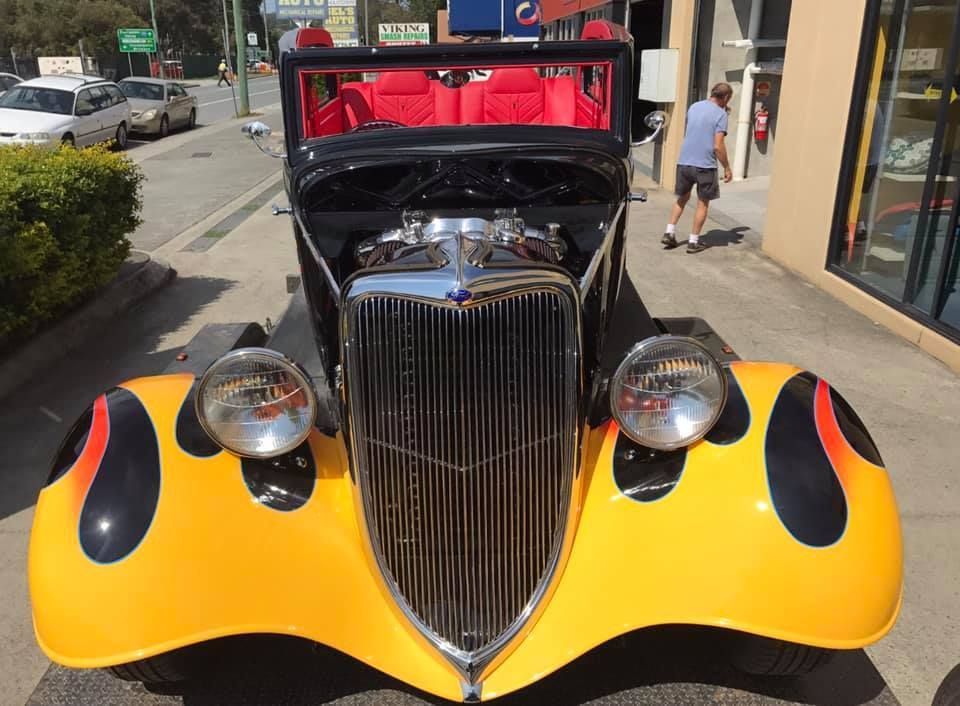 A Yellow Car With Flames Painted on It is Parked on the Side of the Road — Currumbin Trimmers In Tweed Heads, NSW
