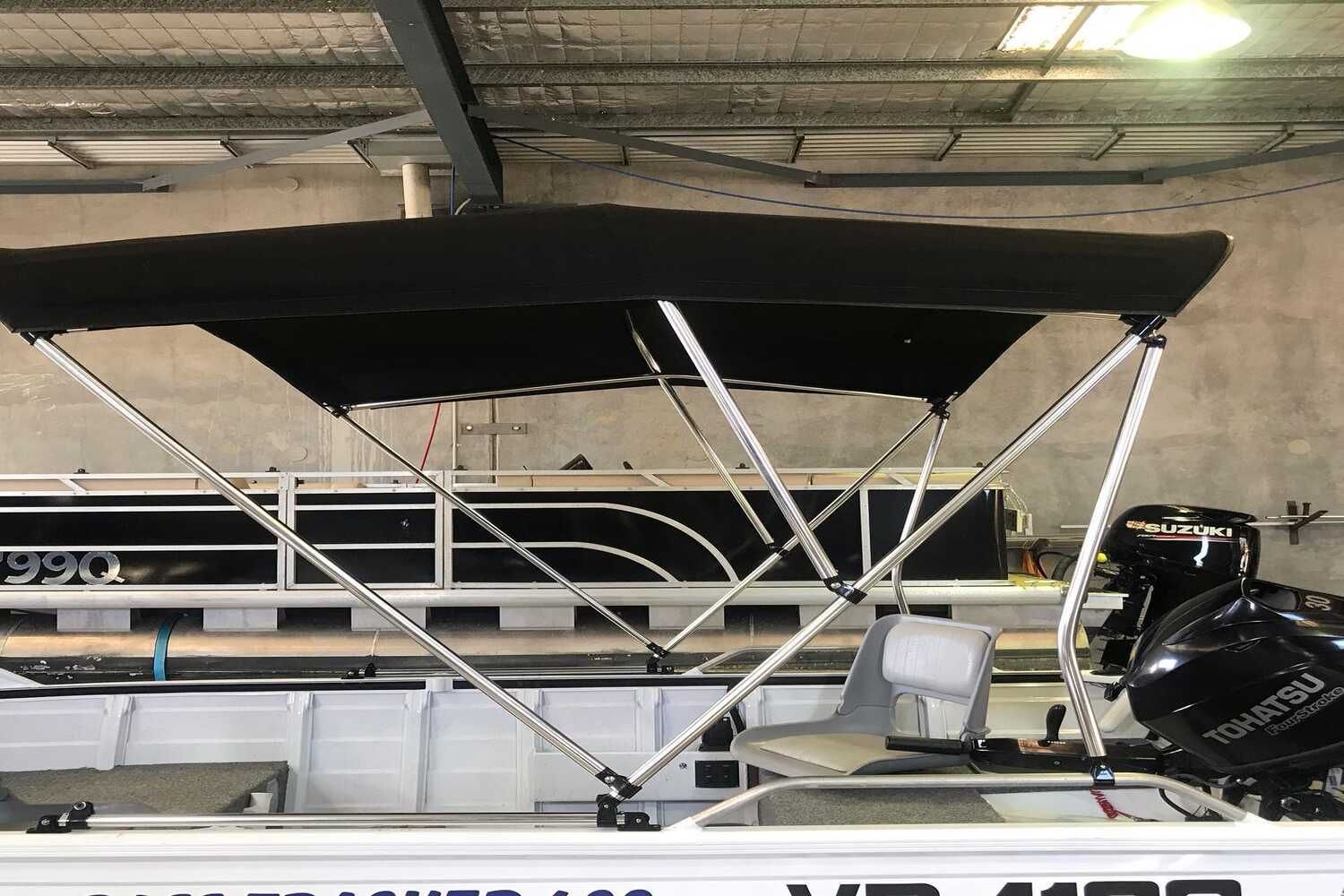 A Boat With A Canopy And A Motor Is Sitting In A Garage — Currumbin Trimmers In Currumbin Waters, QLD