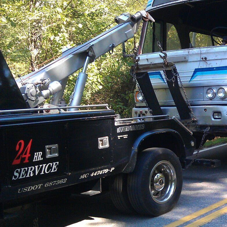 A tow truck says 24 hr service on the side