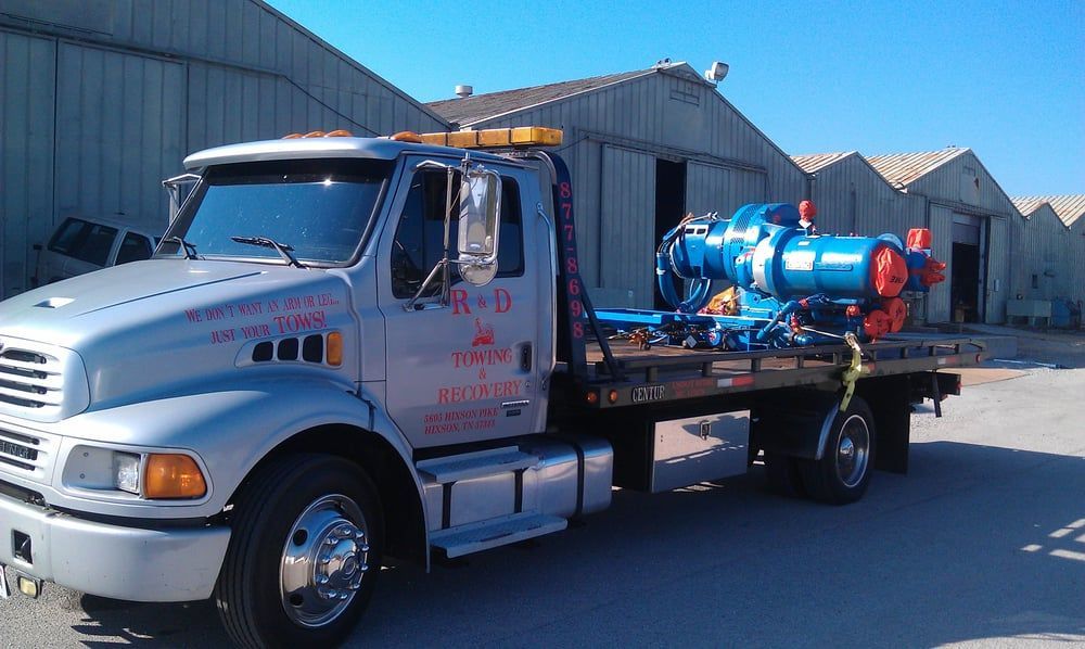 A silver tow truck with the letters n and d on the side