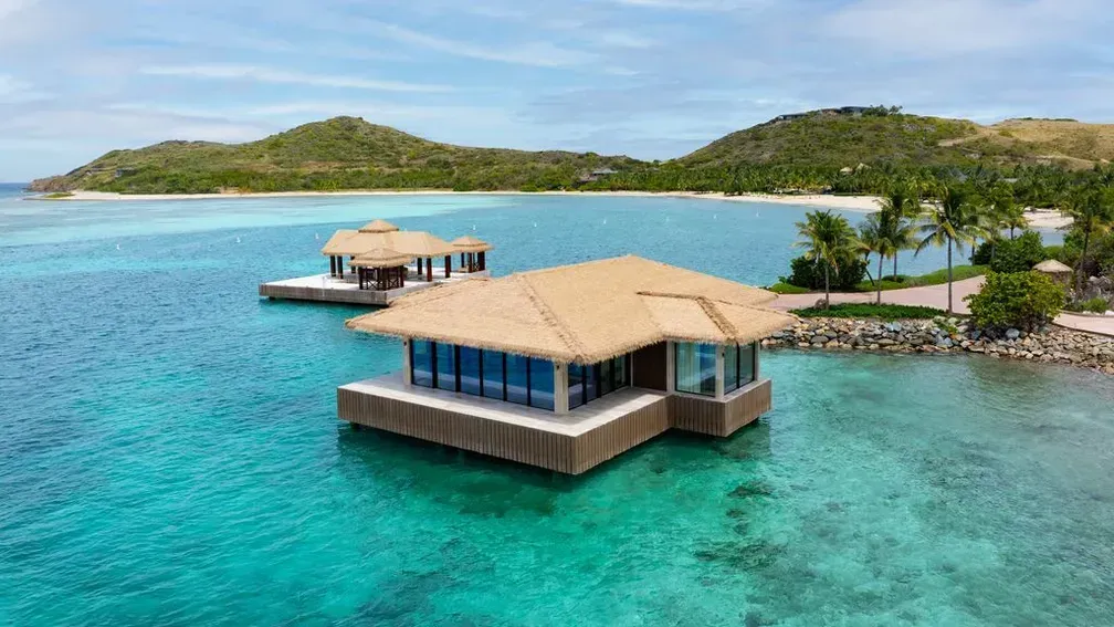 Overwater bungalows in turquoise water with a tropical island backdrop.