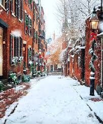 Snow-covered brick alleyway in Boston, lined with buildings decorated for the holidays.