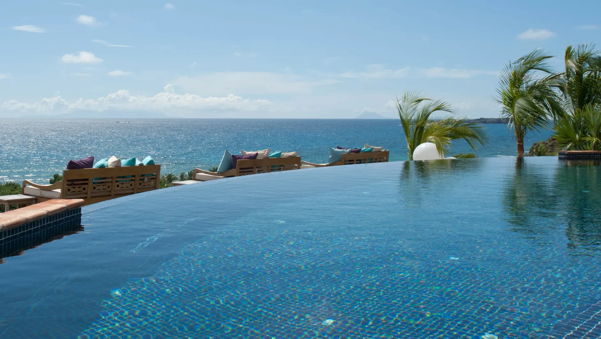 Infinity pool overlooking the ocean under a clear blue sky.