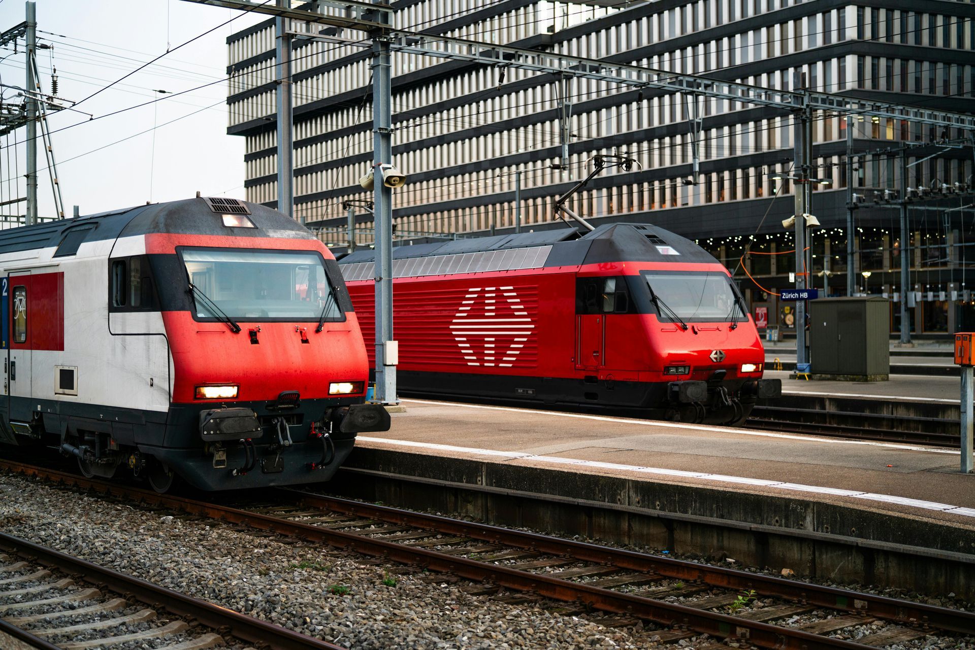 Two trains are parked next to each other at a train station.