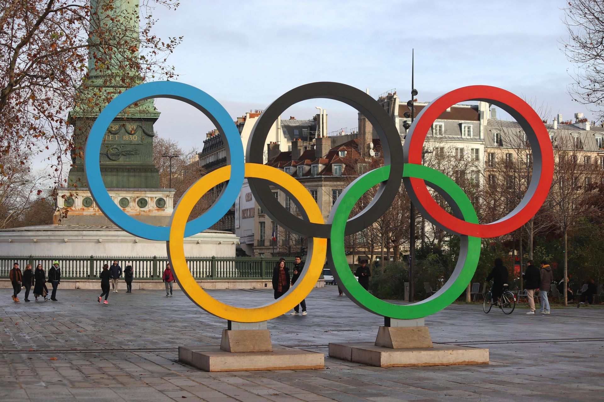 Olympic rings sculpture in Paris, France. Blue, yellow, black, green, and red rings in public square.