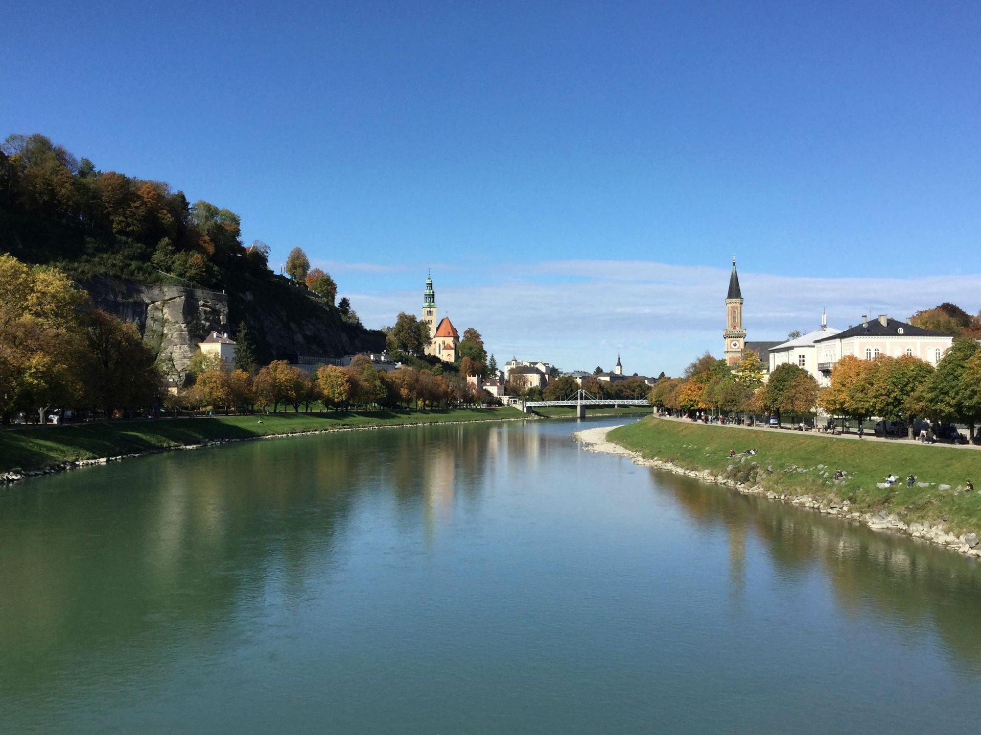 A river surrounded by trees and buildings on a sunny day.