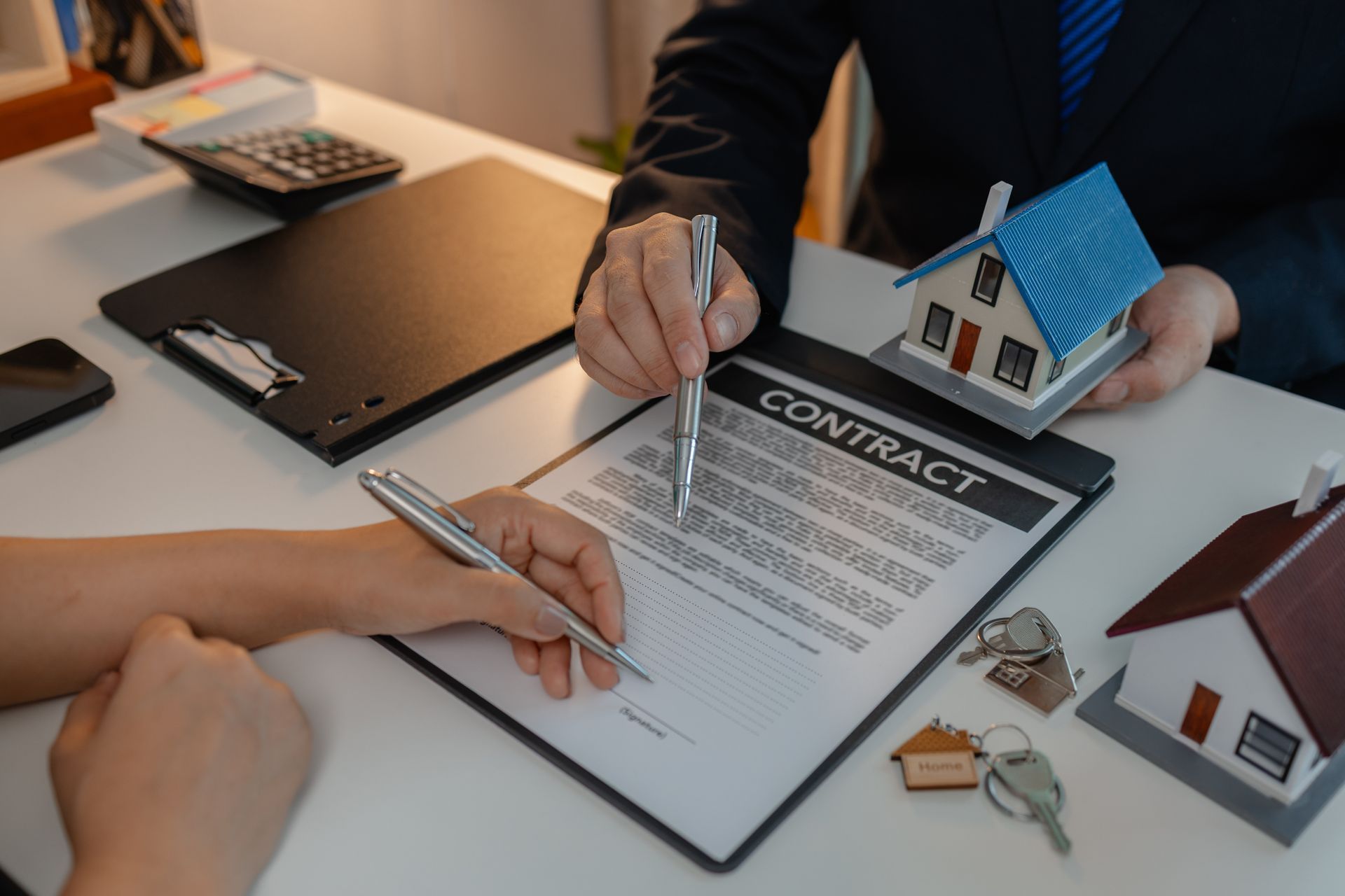 A man and a woman are signing a contract for a house.