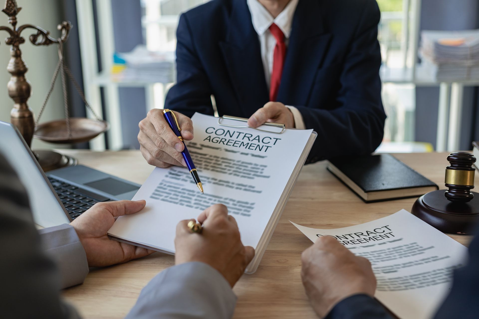 A group of people are sitting at a table signing a contract.