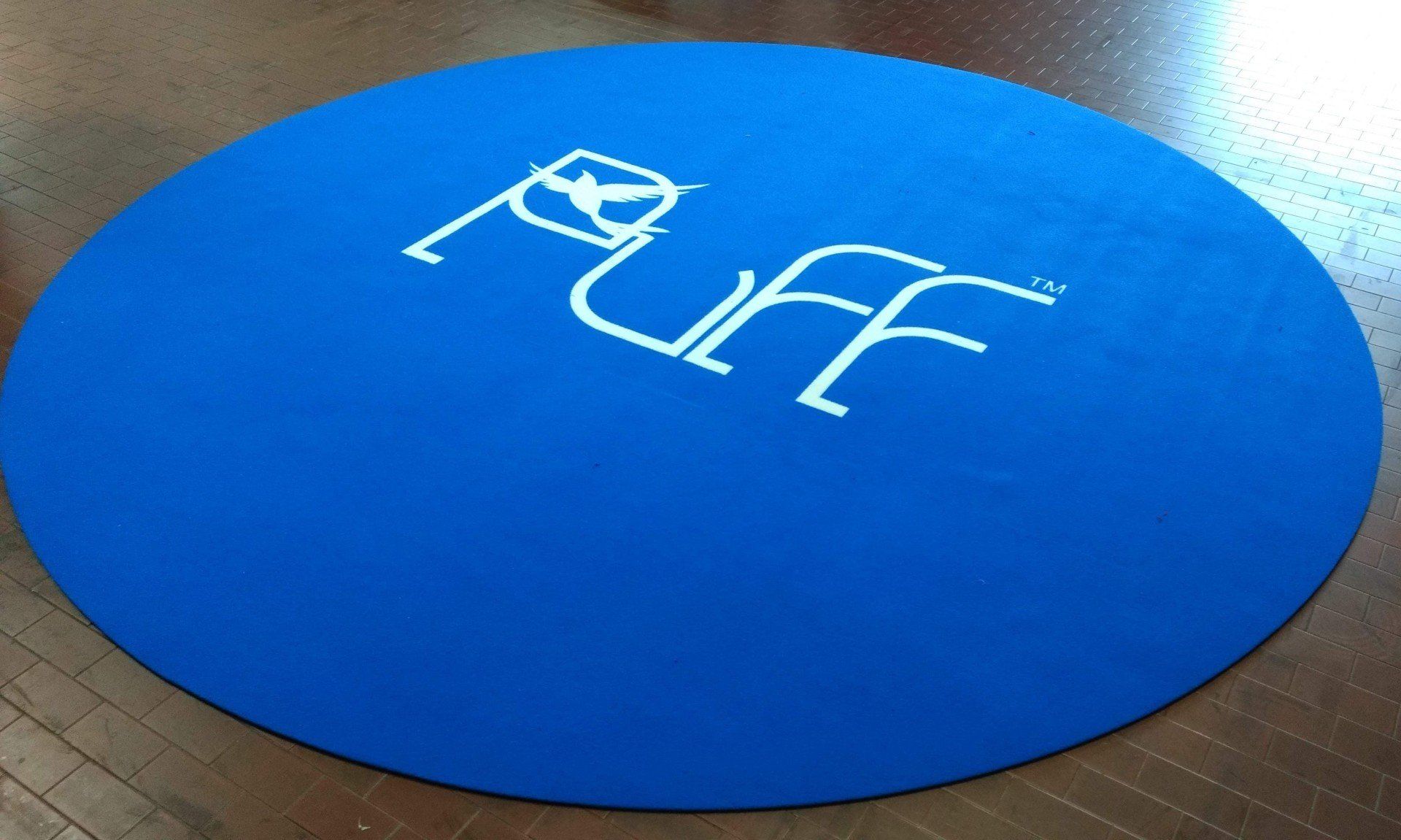 tappeto blu rotondo con logo Puff