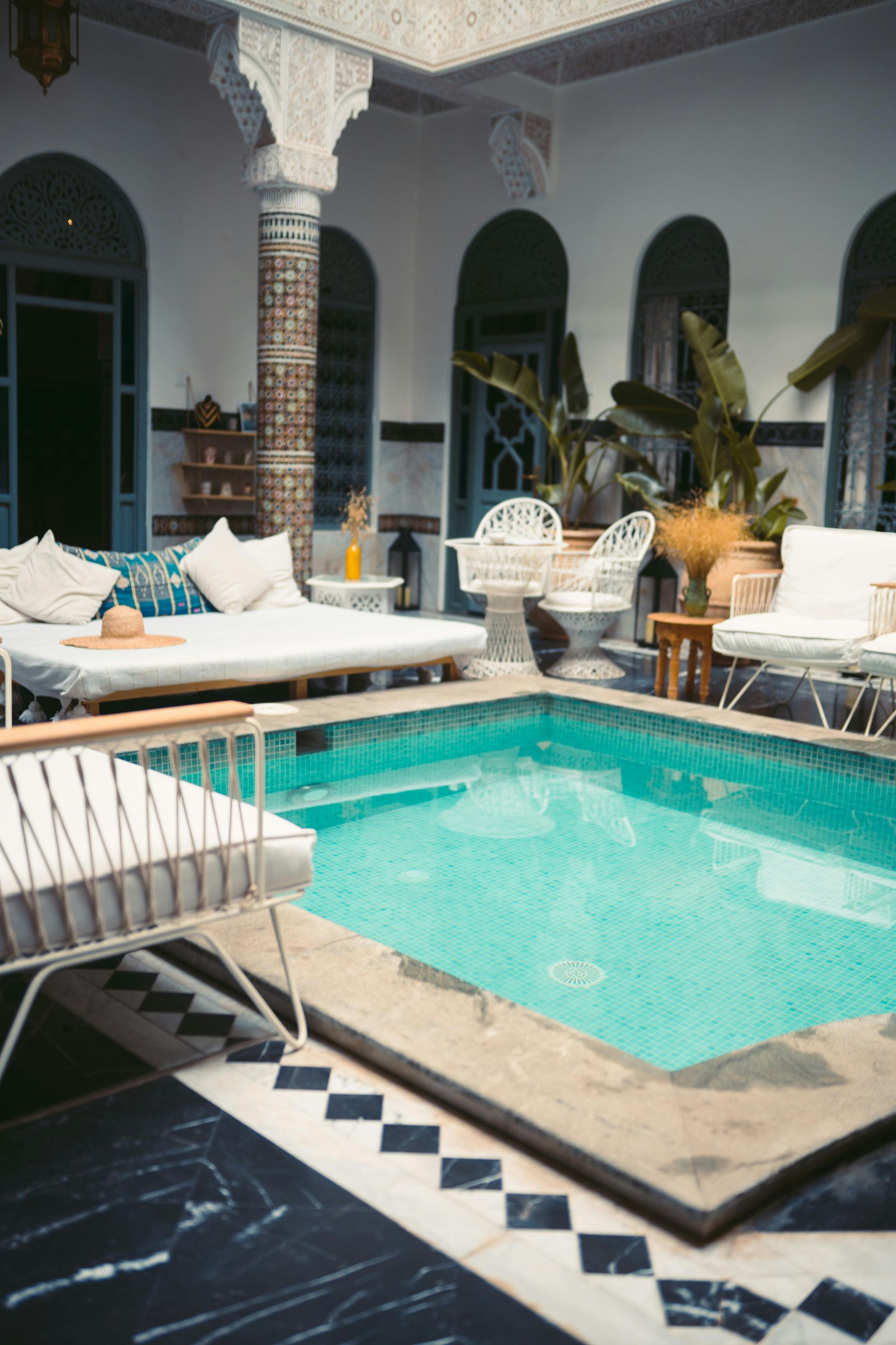 There is a large swimming pool in the middle of a courtyard.