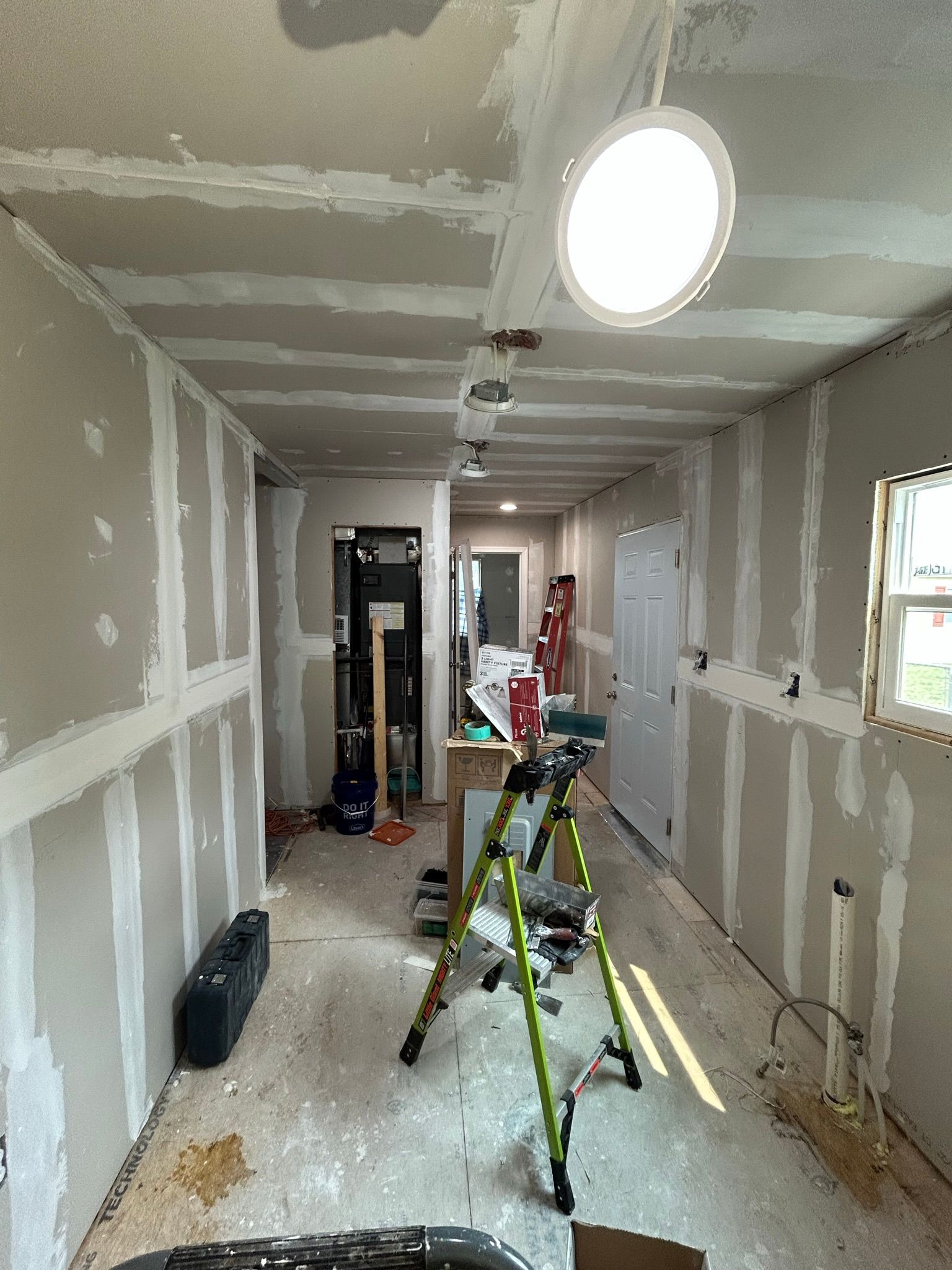 A room with a ladder and a light on the ceiling.